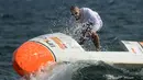 Nicolas Jarossay menjaga keseimbangan papan selancar dayungnya yang dihantam ombak saat berlatih di perairan lepas Martigues, Perancis, Selasa (15/3). Jarossay berencana akan melakukan aksi nekat dengan menyeberangi Samudera Atlantik. (AFP/BORIS HORVAT)