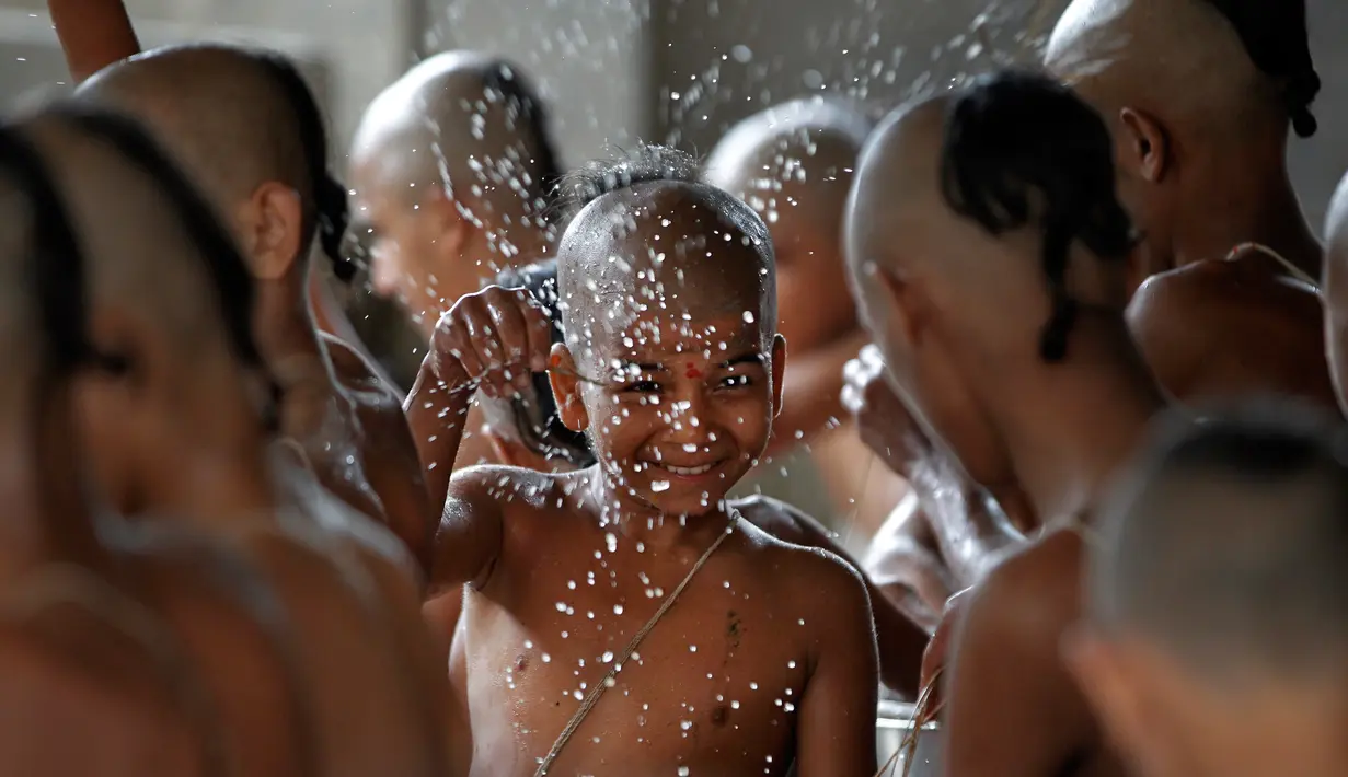 Ekspresi seorang bocah saat mengikuti mandi suci untuk menandai festival Janai Purnima di kuil Pashupati di Kathmandu, Nepal (28/7). (AP Photo / Niranjan Shrestha)