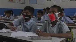 Sejumlah siswa mengenakan masker saat prose belajar mengajar di sebuah sekolah pemerintah di Hyderabad, India, Rabu (4/3/2020). Beberapa siswa memakai masker yang dibuat sendiri, dari kain maupun dari kertas. (AP Photo/Mahesh Kumar A.)