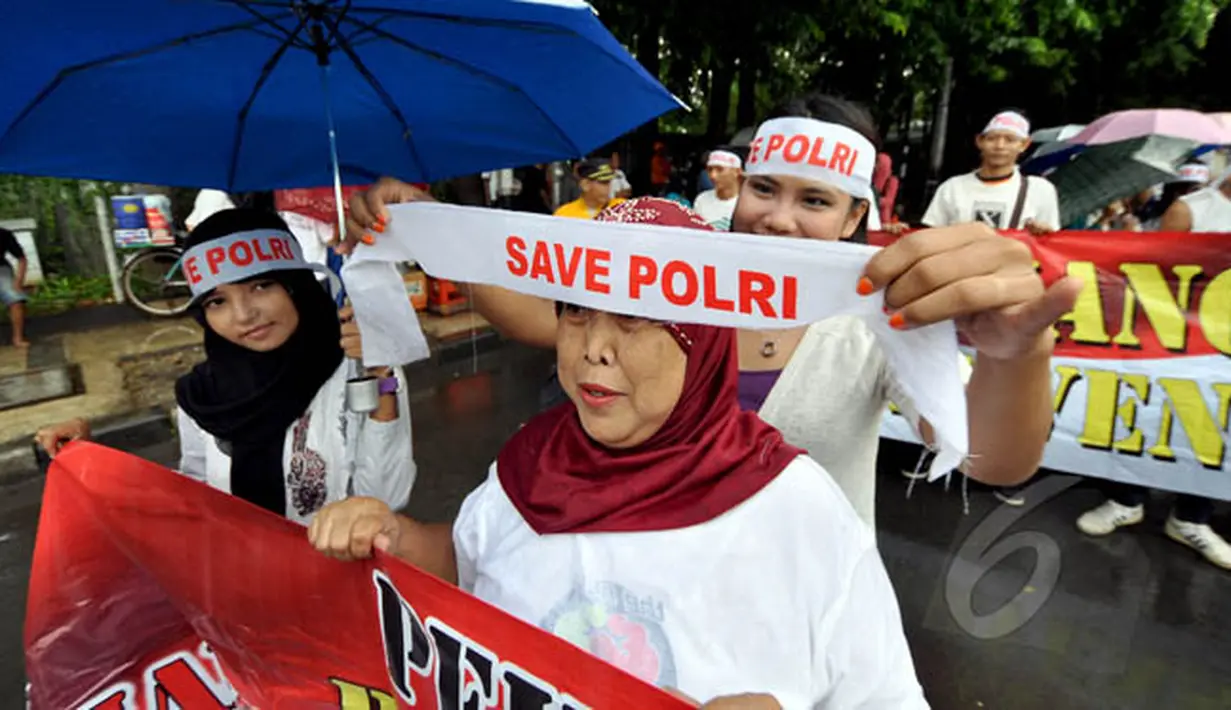 Seorang peserta aksi saat mengenakan ikat kepala bertuliskan 'Save Polri' di kawasan Bundaran HI, Jakarta, Minggu (8/2/2015). (Liputan6.com/Faizal Fanani)