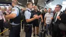 Petugas kepolisian memberi penjelasan kepada calon penumpang di aula terminal 1 Bandara Frankfurt, Jerman, Selasa (7/8). Sejumlah penerbangan harus dibatalkan setelah seorang yang tak dikenal menyusup melewati pos pemeriksaan. (Boris Roessler/dpa via AP)