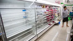 Pembeli memilih bahan makanan dekat rak kosong di sebuah toko, distrik Shinagawa, Tokyo, Sabtu (12/10/2019). Banyak toko-toko perbelanjaan di Jepang yang kehabisan makanan dan minuman akibat warganya yang menimbun makanan untuk menghadapi topan Hagibis. (Odd ANDERSEN / AFP)