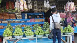 Seorang pria membeli buah mangga yang dijajakan oleh pedagang di Jalur Pantura Indramayu, Jawa Barat, Kamis (29/6). Mangga ini dijual dengan harga mulai Rp 18 ribu hinga Rp 23 ribu per kilogram tergantung jenisnya. (Liputan6.com/Helmi Afandi)