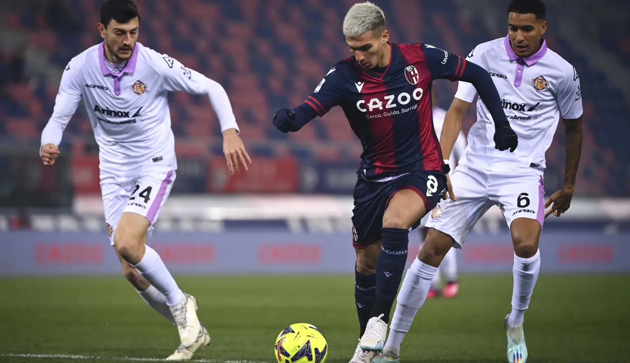 <p>Nicolas Dominguez dari Bologna membawa bola dari kawalan Alex Ferrari dan Charles Pickel dari Cremonese selama pertandingan lanjutan Liga Italia di Stadion Renato Dall'Ara di Bologna, Italia, Selasa (24/1/2023). Hasil imbang tidak mengubah posisi Cremonese di dasar klasemen dengan poin 8. (Massimo Paolone/LaPresse via AP)</p>