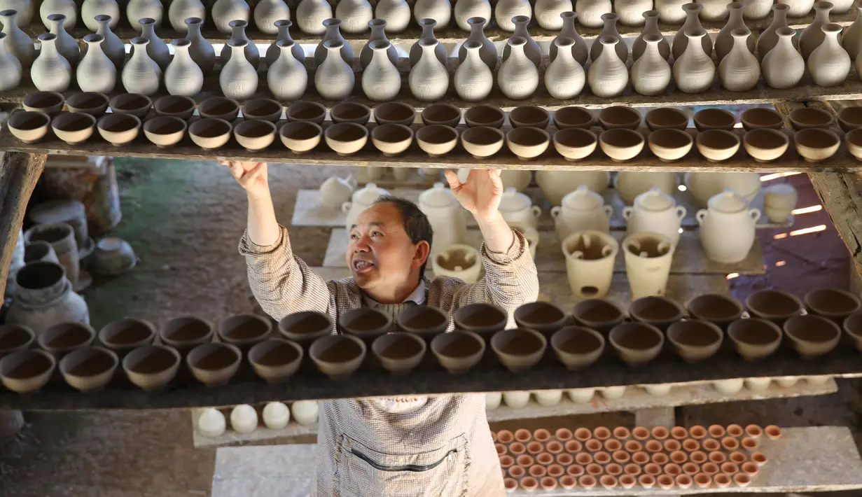 Seorang perajin bekerja di bengkel pembuatan tembikar di Desa Wanyao, sebuah desa di Mazhan yang berada di Tengchong, Provinsi Yunnan, China, 18 November 2020. Wanyao merupakan sebuah desa yang memiliki spesialiasi dalam pembuatan tembikar. (Xinhua/Liang Zhiqiang)