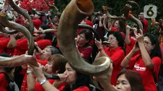 Umat Nasrani memainkan alat musik shofar saat tampil dalam acara Christmas Carol di kawasan Bunderan HI, Jakarta, Jumat (20/12/2019). Alat musik ini terbuat dari tanduk rusa Afrika, cara meniupkannnya bisa dengan nada pendek dan panjang yang memiliki makna yang berbeda. (Liputan6.com/Johan Tallo)