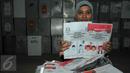 Anggota KPU Depok memperlihatkan surat suara yang rusak sebelum dimusnahkan di Gudang Logistik KPU Depok, Selasa (8/12). 1576 surat suara yang terdiri dari 398 rusak dan 1178 kelebihan tersebut di musnahkan dengan cara dibakar. (Liputan6.com/Yoppy Renato)
