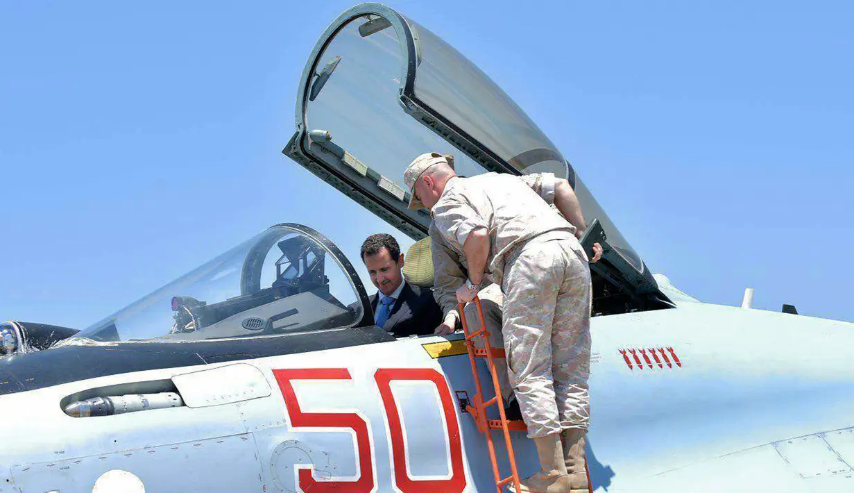 Presiden Suriah Bashar al-Assad berada di kokpit pesawat tempur Rusia Sukhoi SU-35 saat mengunjungi pangkalan udara Rusia di Khmeimim, Selasa (27/6). Assad juga memeriksa senjata, personel dan kendaraan lapis baja. (Syrian Presidency via Facebook)