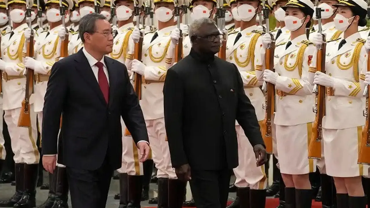 Perdana Menteri Kepulauan Solomon Manasseh Sogavare dan Perdana Menteri China Li Qiang saat meninjau pasukan. (Dok. Andy Wong/AP)