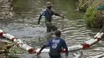 Anggota komunitas Sungai Watch memasang penghalang sampah baru di sebuah sungai di distrik Kerobokan, Bali, pada 14 Desember 2023. (David GANNON/AFP)