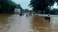 Sejumlah karyawan pabrik menerobos banjir setinggi lebih dari satu meter di depan PT Panasonic Gobel, Cikarang, Kabupaten Bekasi. (Foto: Istimewa)