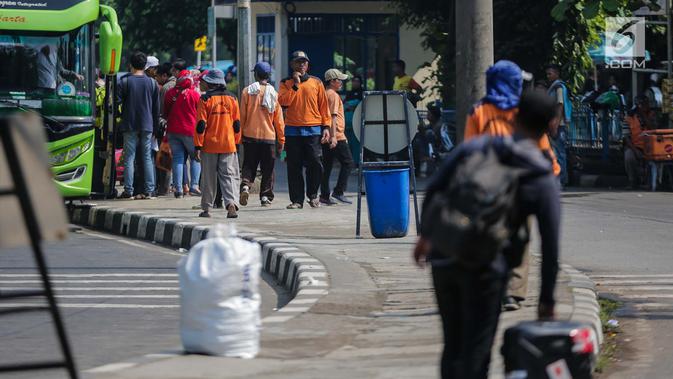 Sejumlah porter menawarkan jasa mengangkut barang bawaan pemudik di Terminal Bus Kampung Rambutan, Jakarta Timur, Minggu (9/6/2019). Jumlah penumpang yang memasuki terminal Kampung Rambutan dalam arus balik Lebaran 2019 diperkirakan bakal memuncak pada Minggu (9/6) ini. (Liputan6.com/Faizal Fanani)
