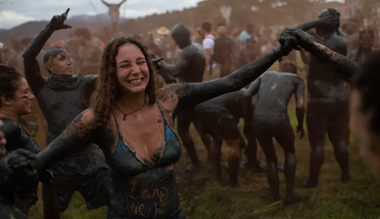 Seorang wanita saat mengambil bagian dalam "Bloco da Lama", pesta mandi lumpur di Paraty, negara bagian Rio de Janeiro, Brasil (2/3). Bermain lumpur di tempat ini merupakan acara tradisional di kota bersejarah, Paraty. (AFP Photo/Mauro Pimentel)