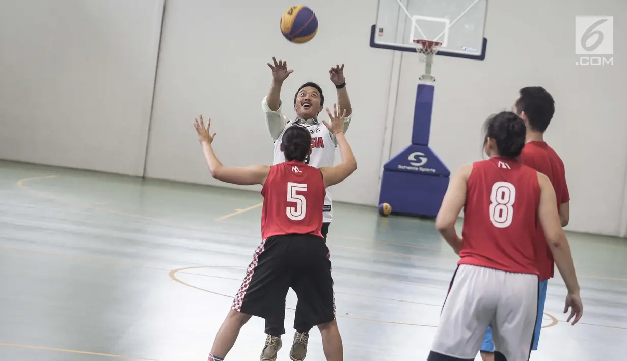 Menpora Imam Nahrawi berupaya memasukan bola saat bermain basket di Lapangan Basket Istana Kana, Jakarta, Jumat (12/1). Menpora mengunjungi Pelatnas Asian Games 2018 cabang olahraga basket untuk meninjau kesiapan para atlet. (Liputan6.com/Faizal Fanani)