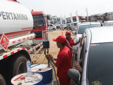 Petugas melakukan pengisian BBM untuk kendaraan pemudik di Rest Area KM 344 Tol Fungsional Pemalang-Batang, Jawa Tengah, Senin (11/6). Selama arus mudik Lebaran 2018, PT Pertamina menyediakan kios BBM. (Liputan6.com/Arya Manggala)