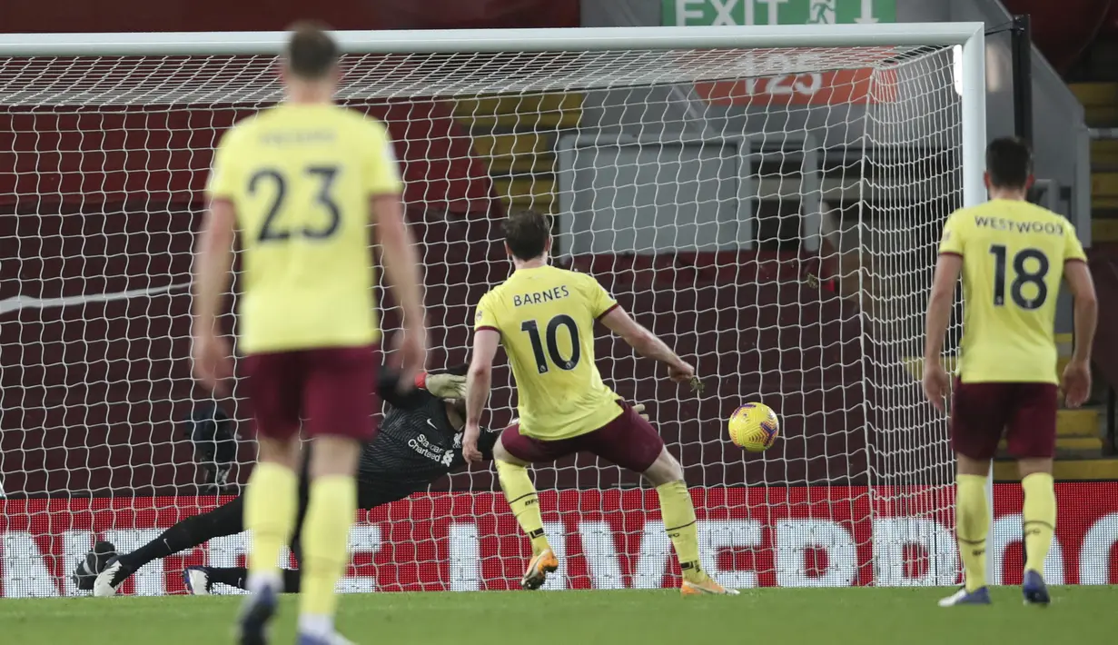 Striker Burnley, Ashley Barnes (tengah) melakukan eksekusi penalti yang gagal diantisipasi kiper Liverpool, Alisson Becker dalam laga lanjutan Liga Inggris 2020/21 di Anfield Stadium, Liverpool, Kamis (21/1/2021). Burnley menang 1-0 atas Liverpool. (AFP/Clive Brunskill/Pool)