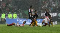 Pemain Persis Solo jatuh bangun menghadapi serbuan Persik dalam hujan deras yang mengguyur Stadion Brawijaya Kediri, Minggu (6/3/2016). Pada uji coba ini Persis kalah 0-5. (Bola.com/Robby Firly)