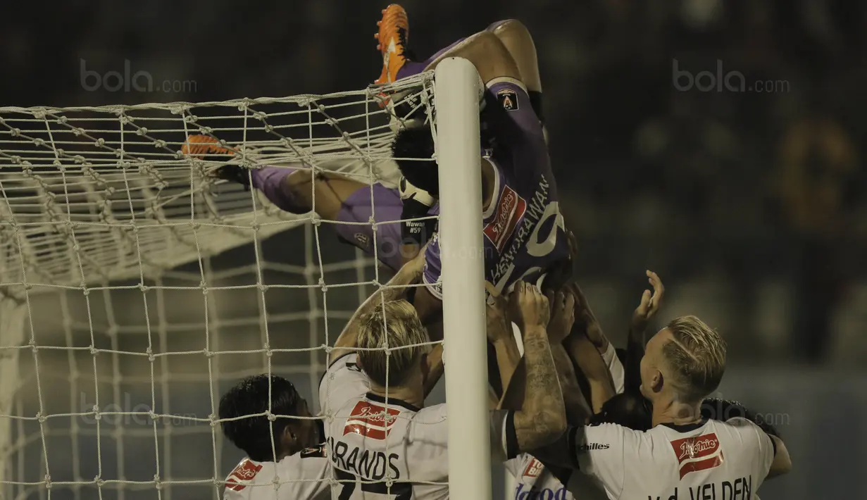 Kiper Bali United, Wawan Hendrawan, melakukan selebrasi panjat tiang gawang usai mengalahkan Madura United pada laga Piala Presiden di Stadion Manahan, Solo, Sabtu, (3/2/2018). Bali United menang adu penalti dengan skor 5-4. (Bola.com/M Iqbal Ichsan)