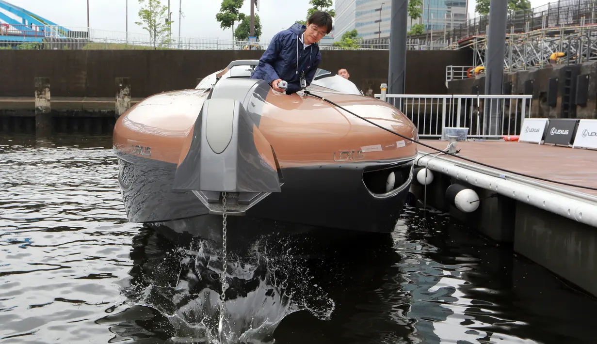 Seorang staf menunjukan cara kerja menurunkan jangkar dari kapal pesiar Lexus di sebuah dermaga di Tokyo, Jepang (26/5). Terinspirasi dari Lumba-lumba Lexus memperkenalkan sebuah konsep kapal pesiar sport yang mewah. (AP Photo/Eugene Hoshiko)