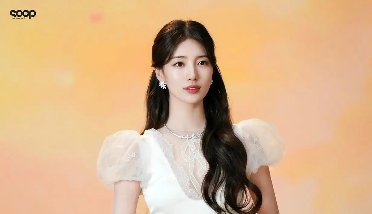 Rambut panjang bergelombangnya dibiarkan terurai lembut, dengan sebagian ditata ke atas untuk menciptakan volume yang pas.  [@skuukzky/@management_soop].