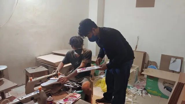 Andyk saat memberikan masukan terkait pewarnaan kepada salah satu pegawai dalam pembuatan handycraft di tempat produksi.