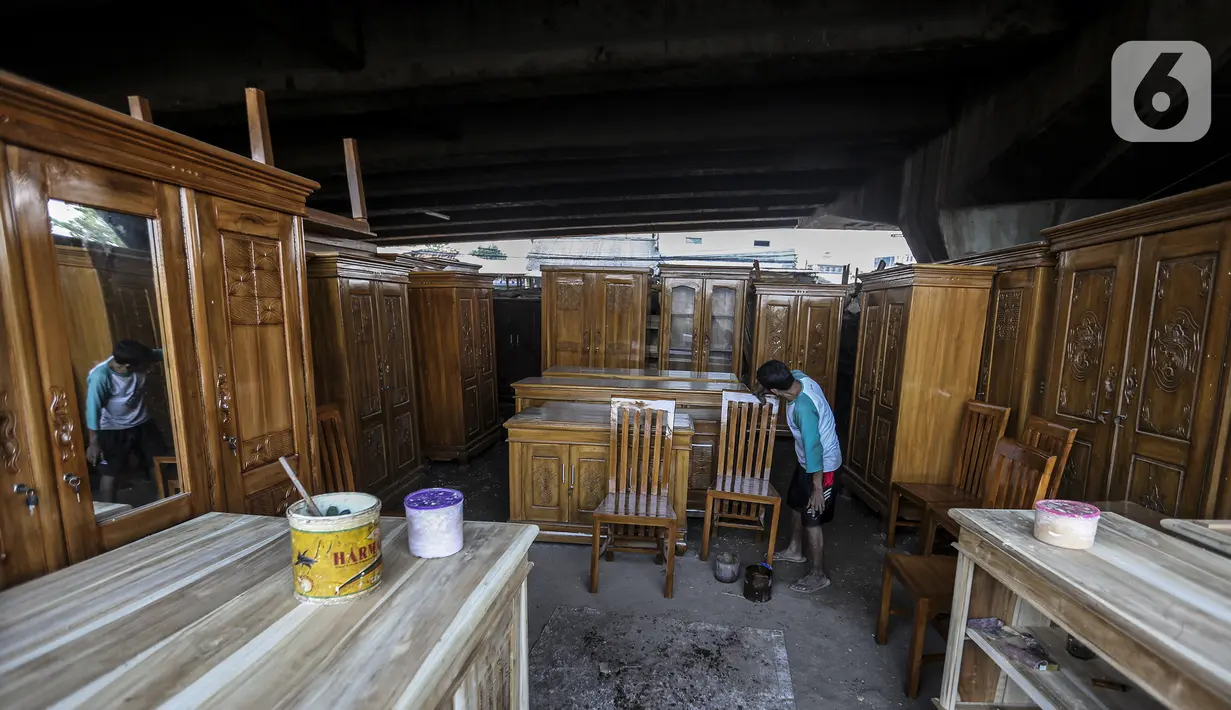 Pekerja menyelesaikan pembuatan furniture (perlengkapan rumah) di kolong Flyover Kranji, Bekasi, Jawa Barat, Sabtu (7/11/2020). Selama pandemi COVID-19 berlangsung, pedagang mengeluhkan daya beli masyarakat yang turun drastis. (Liputan6.com/Johan Tallo)
