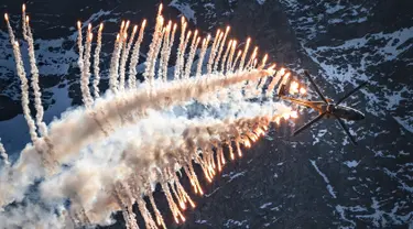 Helikopter Super Puma Cougar melakukan atraksi mengeluarkan "flare" atau suar selama demonstrasi penerbangan Angkatan Udara Swiss di Axalp, 10 Oktober 2018. (Photo by Fabrice COFFRINI / AFP)