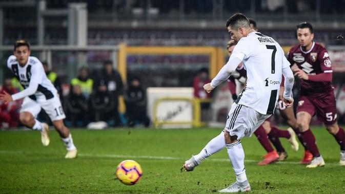 Striker Juventus, Cristiano Ronaldo, mencetak gol dari titik putih ke gawang Torino pada laga Serie A, di Stadion Olimpico, Turin, Sabtu (15/12/2018). (AFP/Marco Bertorello)