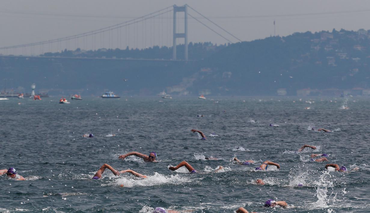 Ratusan atlet renang mengikuti lomba renang dari Asia hingga Eropa di Selat Bosphorus ke-30, Istanbul, Turki, (22/7). Lebih dari 2.000 peserta terjun dari feri dan berenang sejauh sekitar 6,5 km di acara tersebut. (AP Photo/Lefteris Pitarakis)