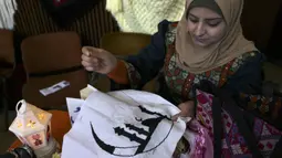 Seorang wanita membuat dekorasi jelang bulan suci Ramadhan di Kota Gaza, Palestina, 31 Maret 2022. Ramadhan di Palestina akan dimulai pada akhir pekan ini. (MOHAMMED ABED/AFP)