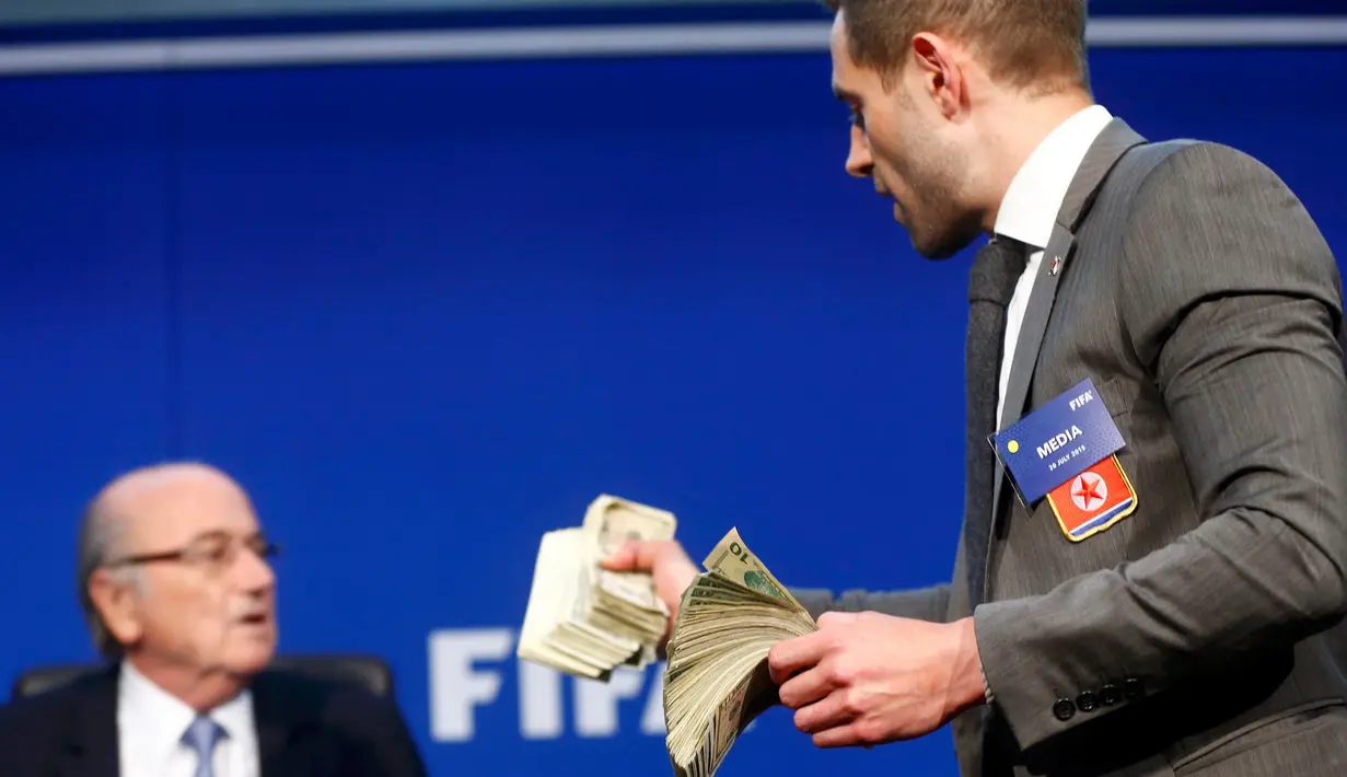Komedian asal Inggris, Lee Nelson sebelum melemparkan uang kertas ke Presiden FIFA Sepp Blatter saat konferensi pers di markas FIFA di Zurich, Swiss (20/7/2015). Kedatangan Nelson membuat jumpa pers tertunda beberapa saat. (REUTERS/Arnd Wiegmann)
