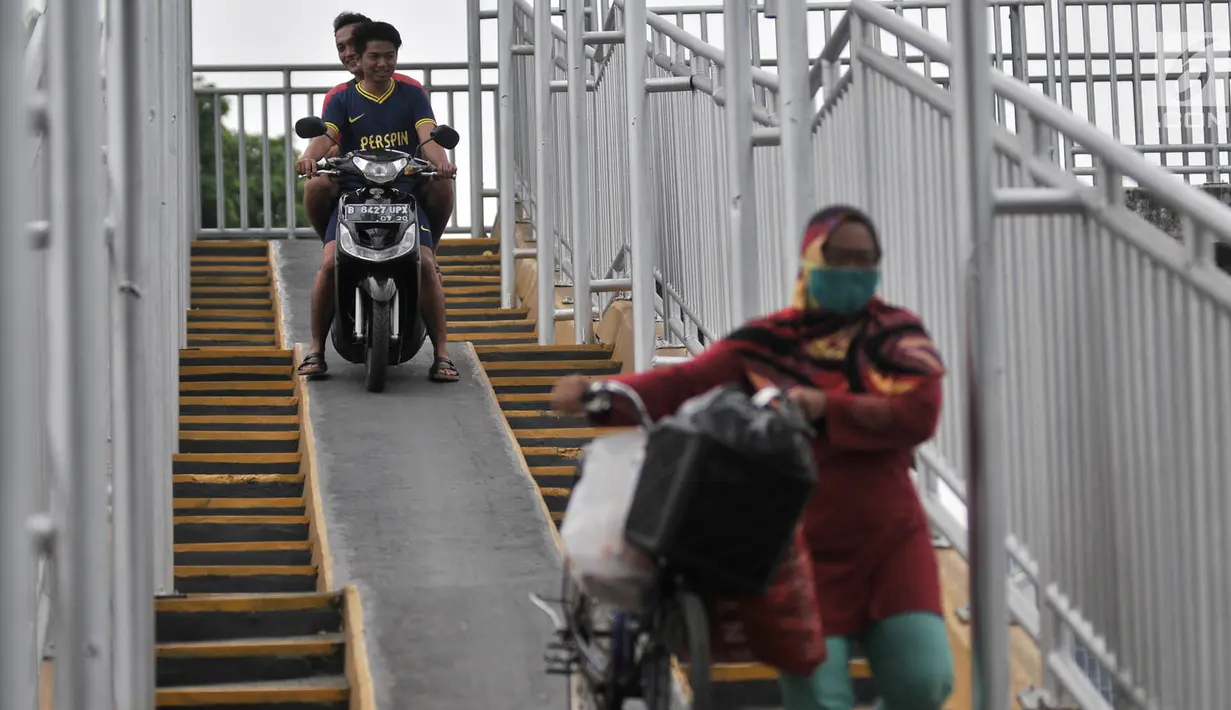 Pengendara sepeda motor melintasi JPO di Jalan Yos Sudarso, Jakarta, Senin (12/11). Aksi nekat yang dilakukan para pengendara sepeda motor demi mempersingkat rute jalan tersebut sangat mengganggu kenyamanan pejalan kaki. (Merdeka.com/Iqbal S. Nugroho)