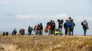 Para migran berjalan menuju gerbang perbatasan Turki dengan Yunani di Ipsala, Edirne, Turki, Selasa (3/3/2020). Ribuan migran dan pengungsi dari Turki dilaporkan berusaha untuk menemukan jalan melintasi perbatasan darat ke Yunani. (AP Photo/Emrah Gurel)