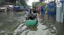 Warga menaiki sampan untuk melewati banjir rob di kawasan Pelabuhan Sunda Kelapa, Jakarta, Selasa (7/12/2021). Banjir rob setinggi satu meter memutus Jalan Kerapu yang menghubungkan Ancol-Pluit. (merdeka.com/Arie Basuki)