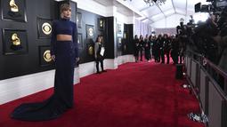 Taylor Swift berpose untuk fotografer di karpet merah ajang Grammy Awards 2023 di Crypto.com Arena, Los Angeles, AS, Senin (6/2/2023) pagi waktu Indonesia. Melansir dari ET Online, para penggemar pun dengan cepat menelusuri bahwa gaun tersebut  memiliki warna yang sama dengan gaun GRAMMY era Fearless-nya dan seperti penampilan GRAMMY 1989-nya, itu adalah pakaian dua potong (two-piece). (Photo by Jordan Strauss/Invision/AP)