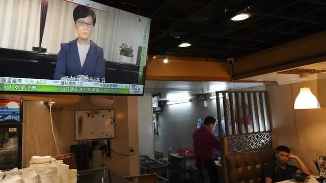 Siaran televisi saat Pemimpin Eksekutif Carrie Lam mengumumkan pencabutan RUU Ekstradisi. (AP Photo/Vincent Yu)