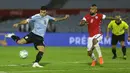 Penyerang Uruguay, Maximiliano Gomez, berusaha melepaskan tendangan ke arah gawang Chile pada laga kualifikasi Piala Dunia 2020 zona Amerika Selatan di Estadio Centenario, Jumat (9/10/2020) pagi WIB. Uruguay menang 2-1 atas Chile. (AFP/Matilde Campodonico/various sources)