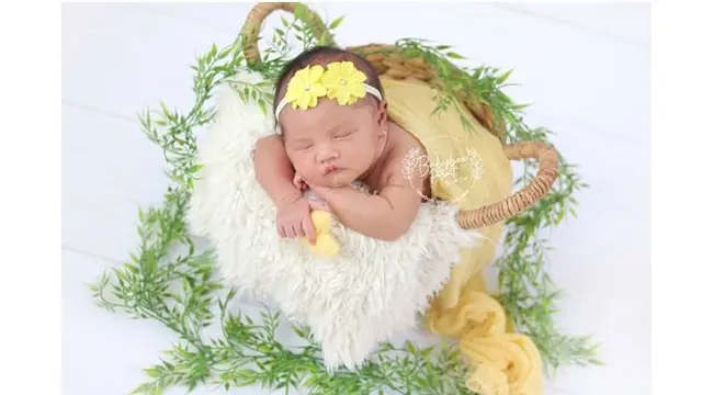 Baby Z mengenakan bando yang mirip dan senada dengan bunga. Sama-sama cantik.