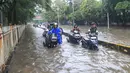 Genangan air tampak merendam beberapa ruas jalan utama, salah satunya Jalan Jembatan Tiga Raya di Jakarta Utara. Tampak dalam foto, pengendara terpaksa mendorong motornya yang mogok saat melintasi banjir yang menggenangi Jalan Jembatan Tiga Raya, Jakarta Utara, Senin (12/1/2026). (merdeka.com/Arie Basuki)