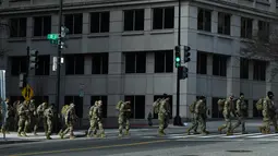 Anggota Garda Nasional berkumpul di Washington, DC, saat pengamanan diperketat pada Senin (18/1/2021). Menurut laporan, 25.000 tentara Garda Nasional akan menjaga kota tersebut sebagai persiapan untuk pelantikan Joe Biden sebagai Presiden ke-46 Amerika Serikat. (Brendan Smialowski/AFP)