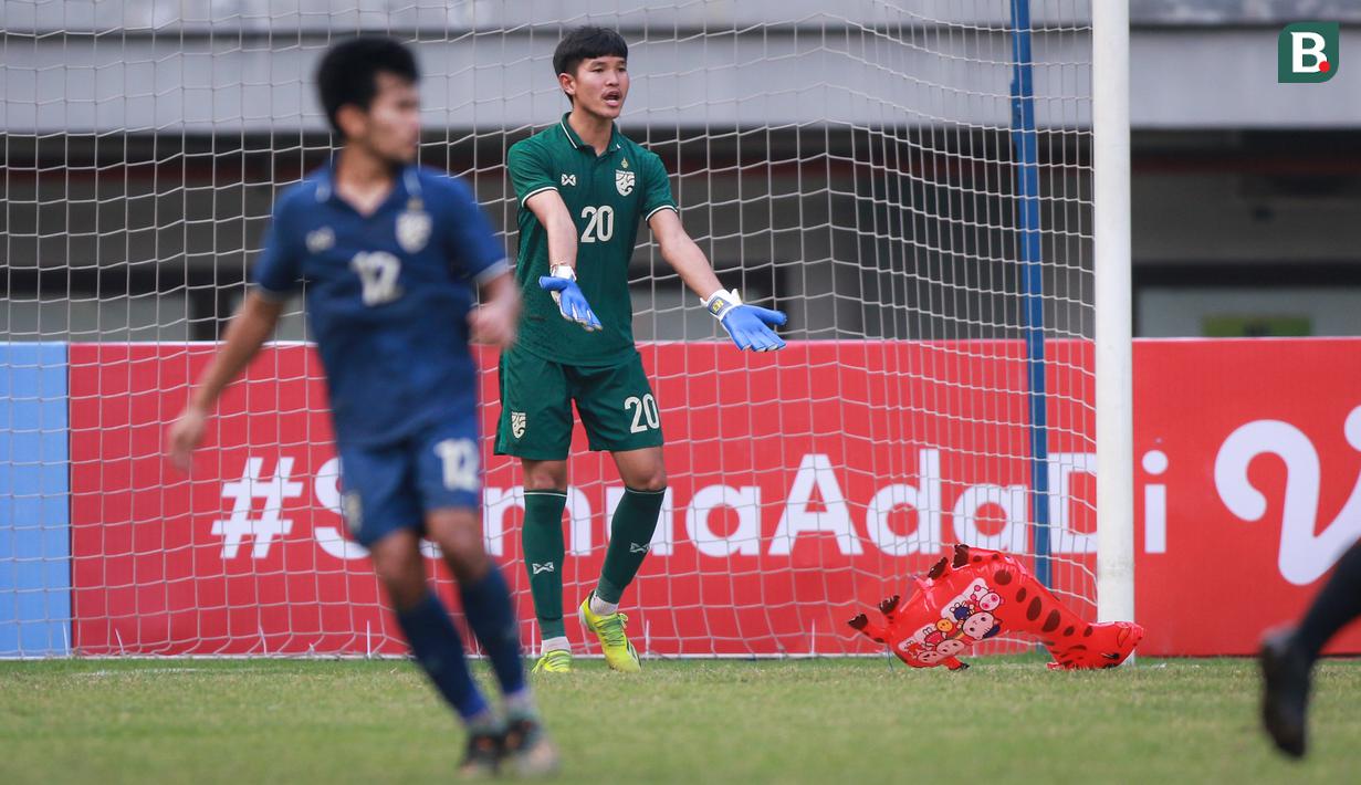 Kiper Timnas Thailand U-19, Chommaphat Boonloet memberikan isyarat untuk menunda pertandingan saat balon berbentuk jerapah memasuki lapangan pada laga perebutan juara ketiga Piala AFF U-19 2022 antara Timnas Vietnam U-19 melawan Timnas Thailand U-19 yang berlangsung di Stadion Patriot Candrabhaga, Bekasi (15/07/2022). (Bola.com/Bagaskara Lazuardi)