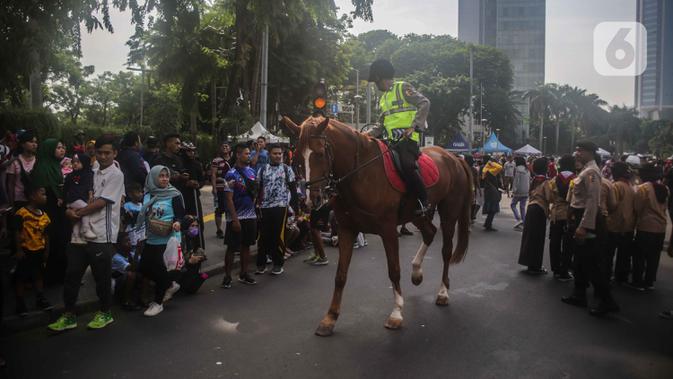 Polisi berkuda dari Direktorat Polisi Satwa Mabes Polri mengawasi keamanan di kawasan Bundaran HI, Jakarta, Minggu (17/11/2019). Polisi berkuda tersebut khusus ditugaskan mengawasi keamanan CFD serta memperkenalkan kepada warga. (Liputan6.com/Faizal Fanani)