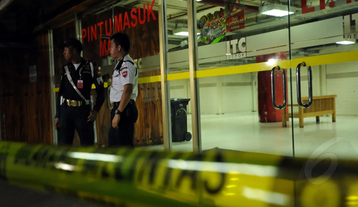 Dua petugas keamanan berjaga di depan salah satu pintu masuk Mall ITC Depok, Jawa Barat, Selasa dini hari (24/2/2015). Sebuah ledakan kecil terjadi di Mall ITC Depok pada Senin (23/2/2015). (Liputan6.com/Helmi Fithriansyah)
