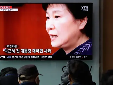 Warga menyaksikan layar TV yang menyiarkan berita tentang mantan presiden Korea Selatan Park Geun-hye, Seoul, Korea Selatan, Jumat (6/4). Pengadilan Korea Selatan menjatuhkan hukuman penjara selama 24 tahun untuk Park Geun-hye. (AP Photo/Lee Jin-man)