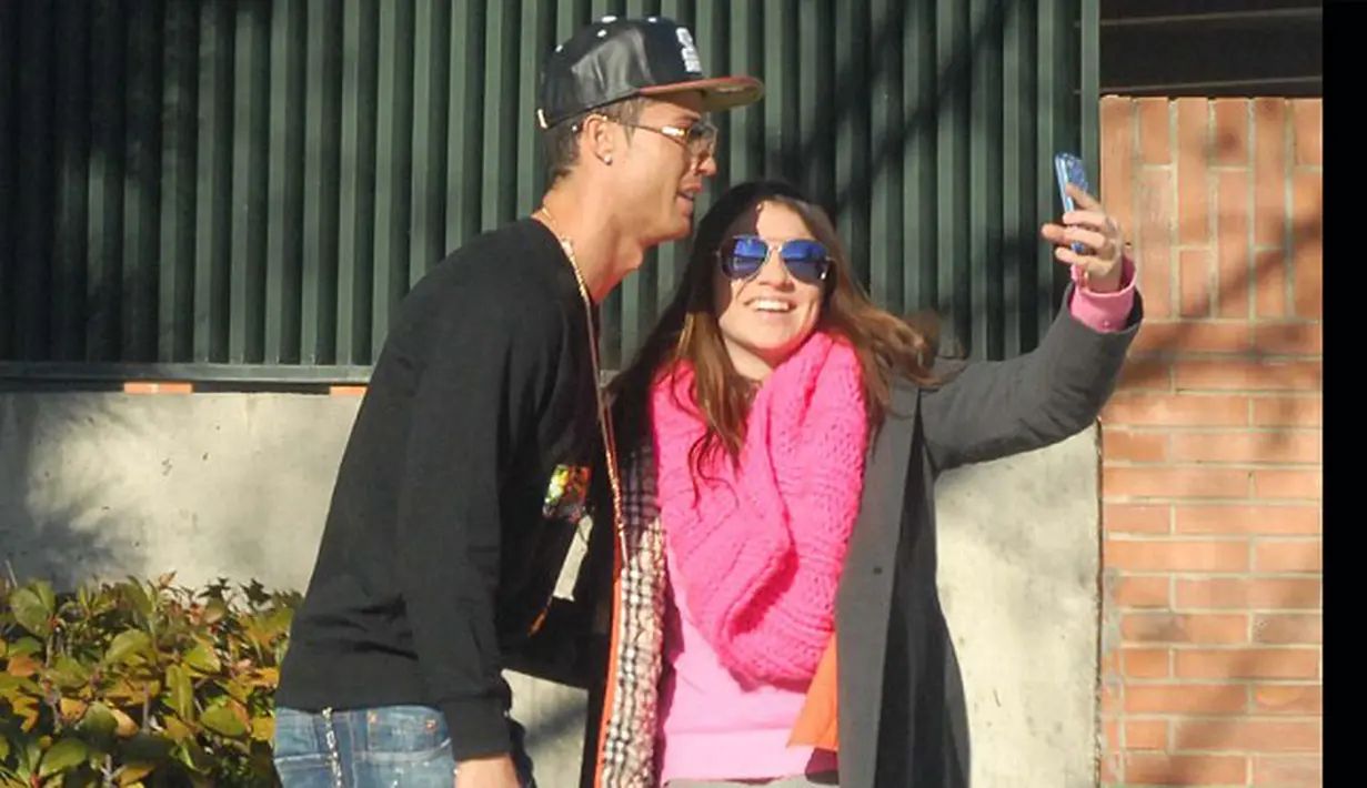 Seorang fans meminta Cristiano Ronaldo untuk berpose bersama saat akan menjemput anaknya di sekolah, Madrid, Selasa (27/1/2015). (Dailymail)