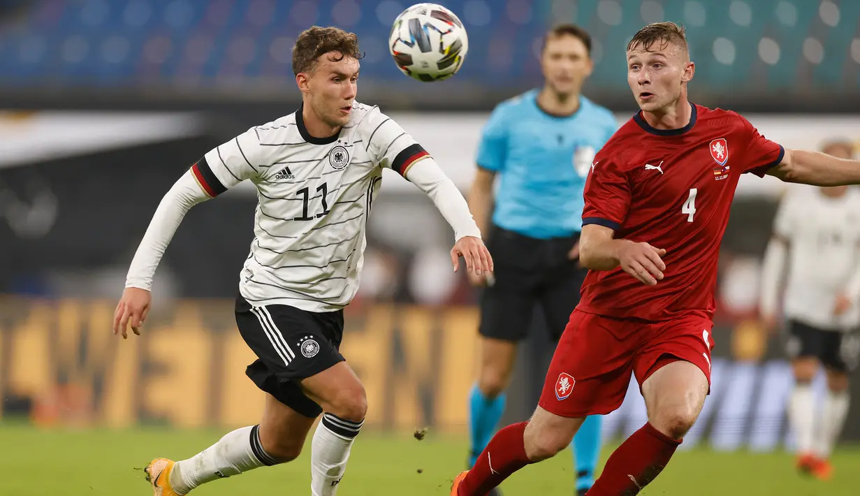 Penyerang Jerman, Luca Waldschmidt, berebut bola dengan bek Republik Ceko, Jakub Brabec, pada laga uji coba di RB Arena, Kamis (12/11/2020) dini hari WIB. Jerman menang 1-0 atas Republik Ceko. (AFP/Odd Andersen)
