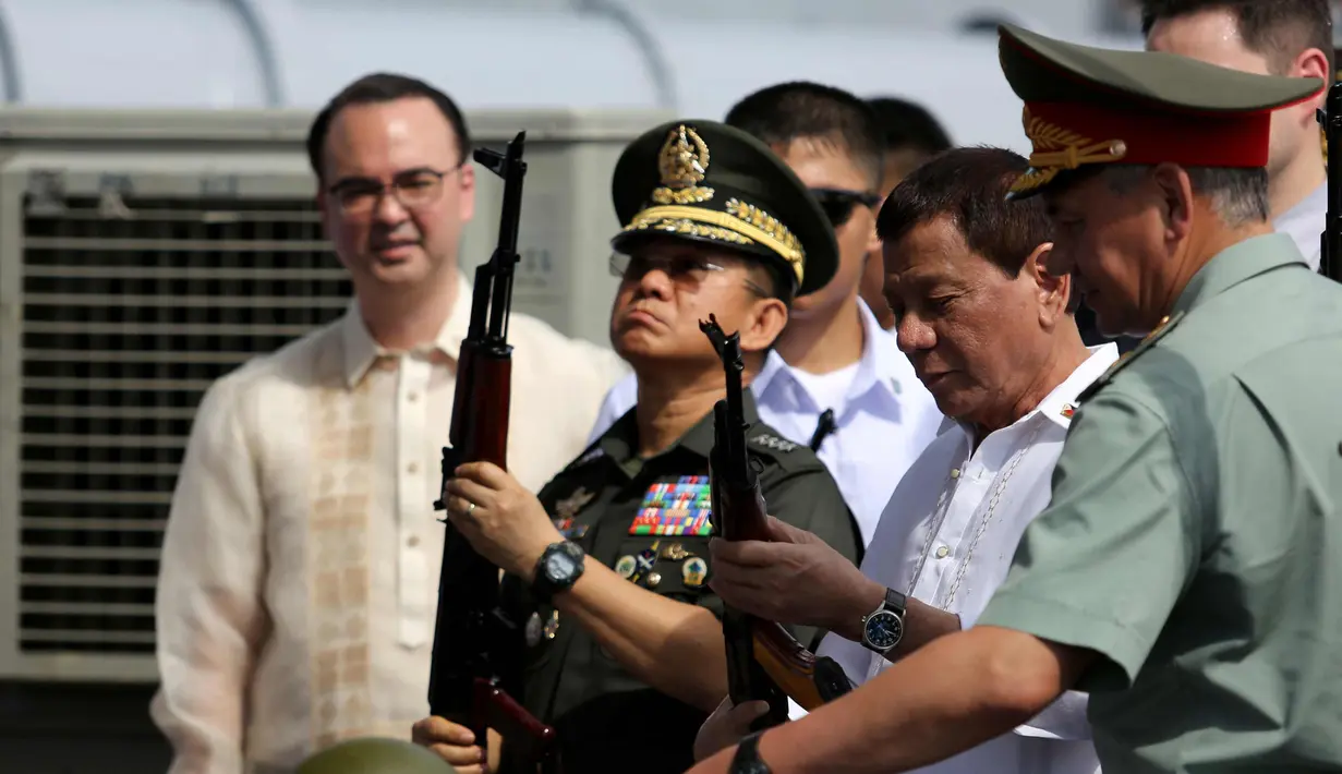 Presiden Filipina Rodrigo Duterte (kedua kanan) memeriksa senapan serbu AK-47 Kalashnikov sumbangan dari Rusia di atas kapal perusak Rusia Admiral Panteleyev di pelabuhan Metro Manila, Filipina (25/10). (AFP Photo/Robinson Ninal)