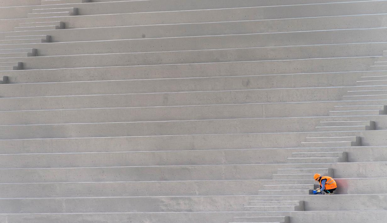 Pekerja saat menyelesaikan proyek pembangunan Stadion Nizhny Novgorod, Rusia, Selasa (19/9/2017). Stadion ini merupakan salah satu dari 12 stadion yang akan digunakan untuk perhelatan akbar Piala Dunia 2018 di Rusia. (AFP/Mladen Antonov)