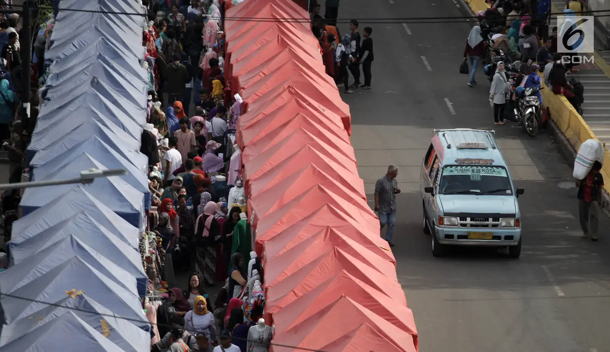 Angkutan kota Tanah Abang kembali melintasi Jalan Jatibaru Raya, Jakarta, Sabtu (3/2). Angkot hanya diperbolehkan melintas di satu ruas jalan saja, depan Stasiun Tanah Abang dan satu ruas lagi tetap digunakan PKL berjualan. (Liputan6.com/Arya Manggala)