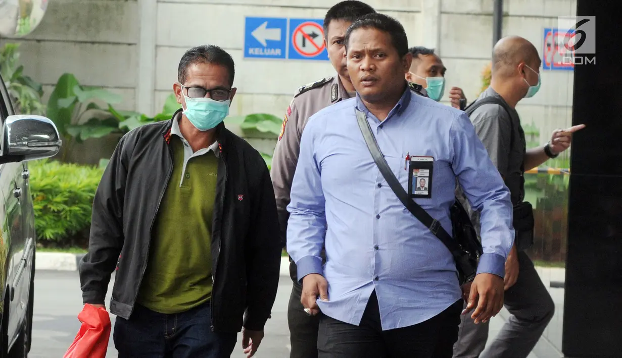 Bupati Mesuji Khamami (kiri) tiba di Gedung KPK, Jakarta, Kamis (24/1). Khamami tak bersedia memberikan pernyataan sedikit pun kepada awak media. (Merdeka.com/Dwi Narwoko)